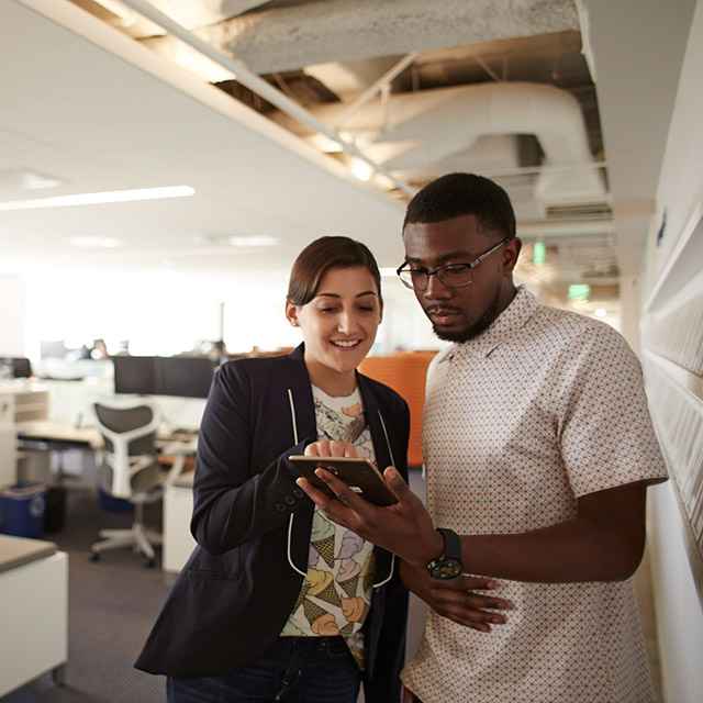 Two people looking at a tablet.